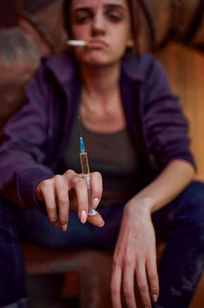 Drug addict female person holds syringeの写真素材