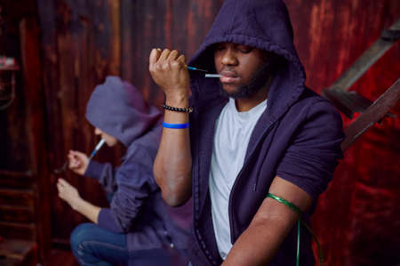 Drug addict man and woman with syringes in denの写真素材