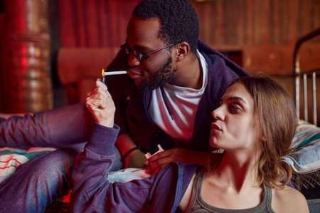 Drug addicts smokes a cigarette while high in denの写真素材