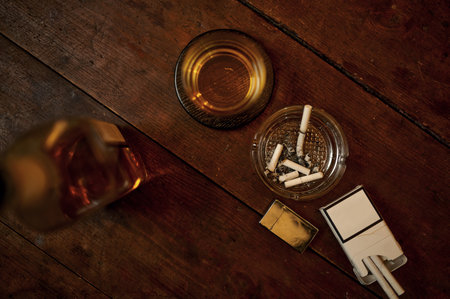 Cigarettes in ashtray, alcohol in bottle, top viewの写真素材