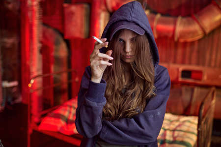 Drug addict woman with cigarette in hellhole