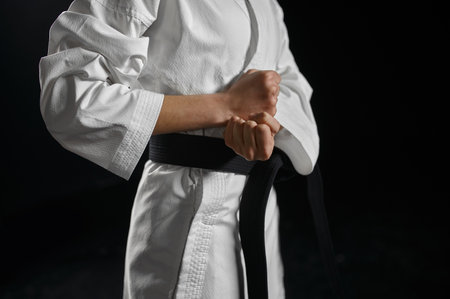Karate fighter in white kimono having black beltの写真素材
