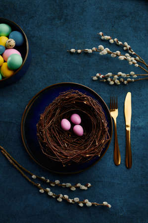 Willow branch, easter eggs in nest and tableware