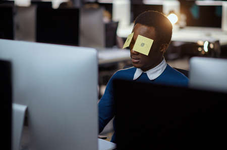 Stressed young manager works in night office