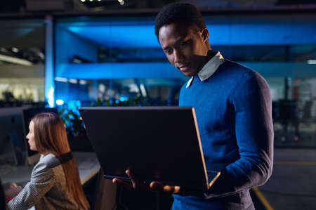 One manager works on laptop in night office