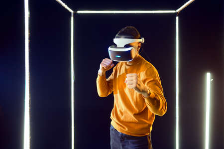 Young gamer fighting in virtual reality headset