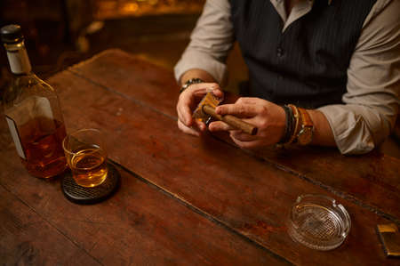 Man with guillotine cuts a cigar, tobacco smokingの写真素材