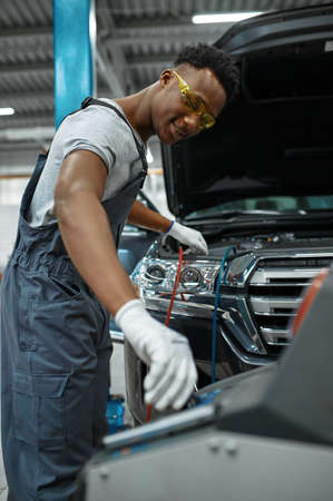 Male worker refills air conditioner, car serviceの写真素材