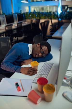 Manager sleeping at table, night office lifestyleの写真素材