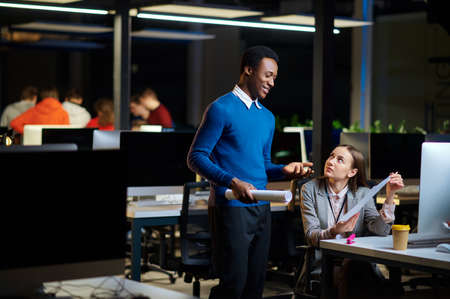Cheerful managers works in night office