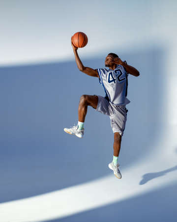 Basketball player with ball, high jump in actionの写真素材