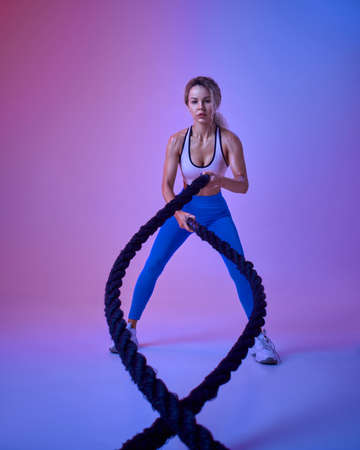 Young sportswoman with ropes in studioの写真素材