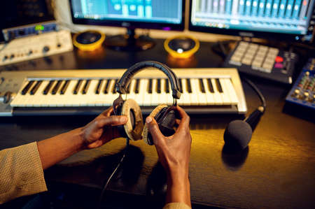 Sound engineer holds headphones, recording studioの写真素材