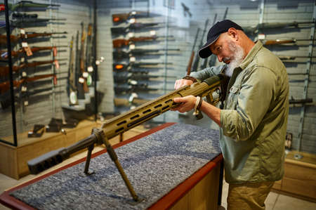 Bearded man reload powerful rifle in gun store