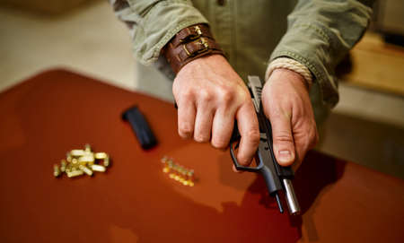 Man loads the gun with bullets in gun store