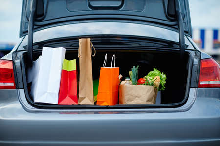 Car with cardboard bags in opened trunk