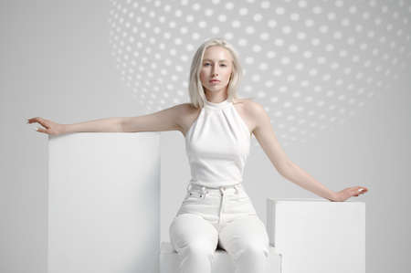 Futuristic young woman sitting on cube