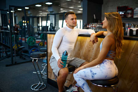 Sportive couple relax at the counter in gym barの写真素材