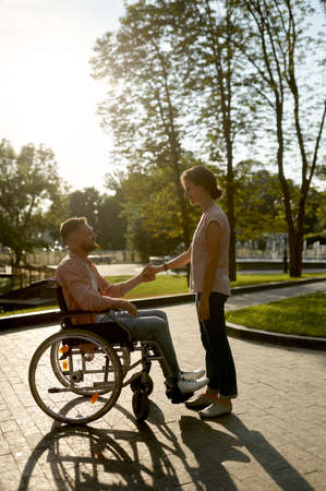 Family couple with wheelchair walking in parkの写真素材