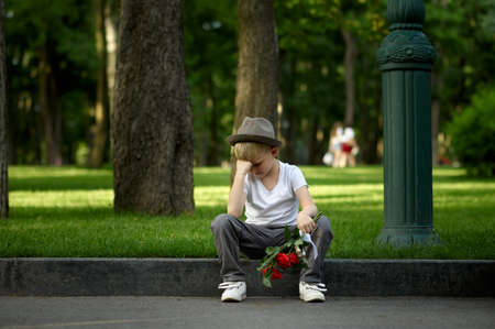 Sad boy with bouquet, girl did not come on a dateの写真素材