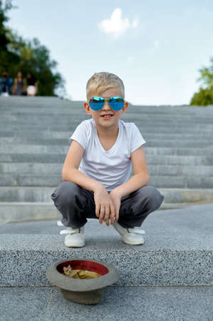 Fashionable macho boy waiting for a girl on stairsの写真素材