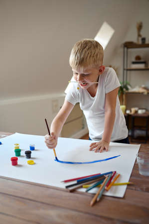 Little boy drawing with gouache on his faceの写真素材