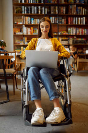 Disabled student in wheelchair works on laptopの写真素材