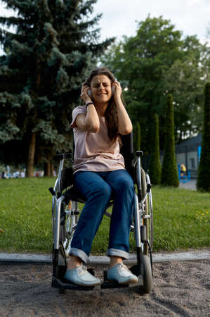 Disabled woman in wheelchair listens to musicの写真素材
