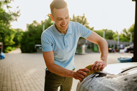 Man using sponge with foam, hand car washの写真素材