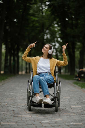 Disabled woman in wheelchair listens to musicの写真素材