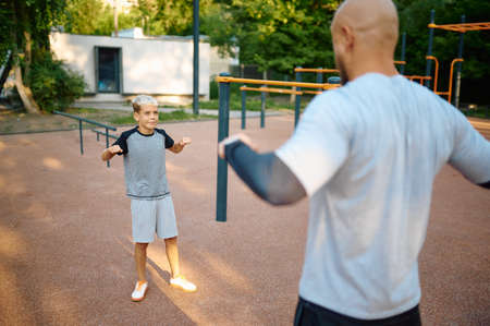 Dad and son, sport training on playground