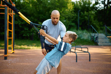 Father and son, exercise with ropes on playgroundの写真素材