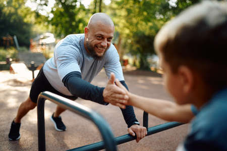 Cheerful father and son, sport training outdoors