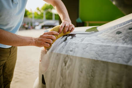 Man using sponge with foam, hand car washの写真素材