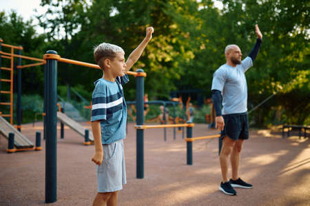 Dad and son, sport training on playground