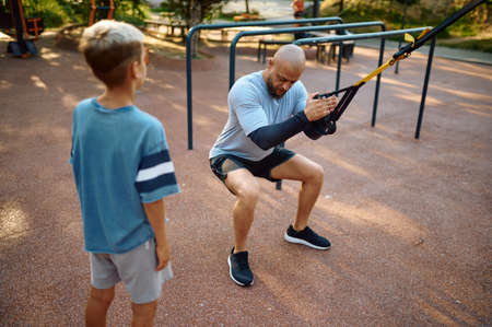 Father and boy, exercise with ropes on playground