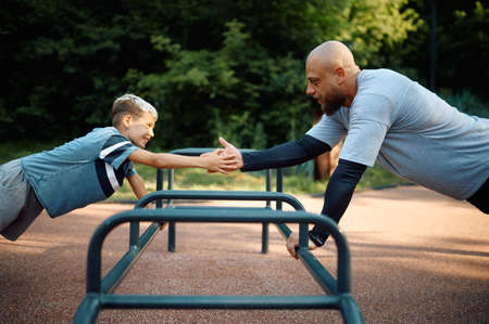 Father and boy, push-up exercise on playgroundの写真素材