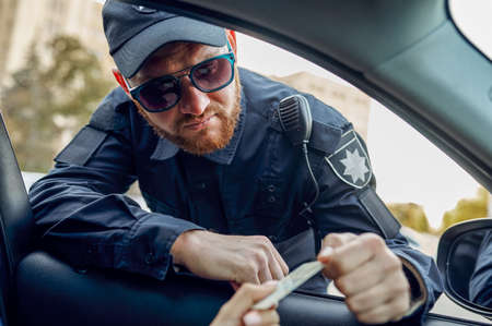 Police officer takes drivers license from driver