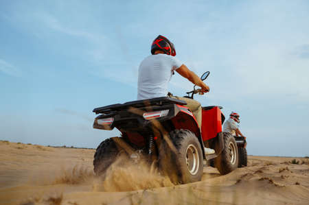 Two racers in helmets ride on atv, action view