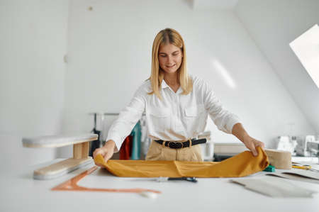 Seamstress works with cloth pattern in workshop