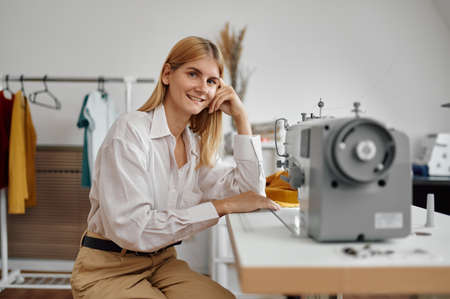 Seamstress works on sewing machine at workplaceの写真素材