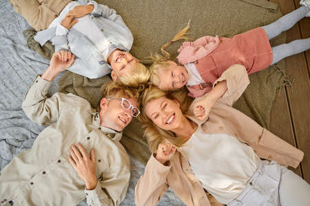 Happy family lying on blankets, top view, camping