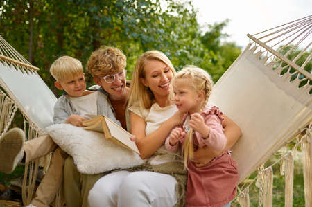 Cheerful family having fun on hammock, camping
