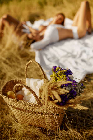 Backet in field, sexy women lying on backgroundの写真素材