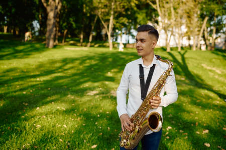 Young saxophonist plays melody on golden saxophoneの写真素材