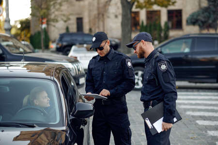 Male police officers checking the drivers licenseの写真素材