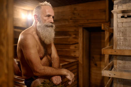 Grey-haired senior man rest at bath houseの写真素材