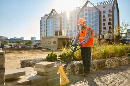 Builder using hand loader at construction siteの写真素材