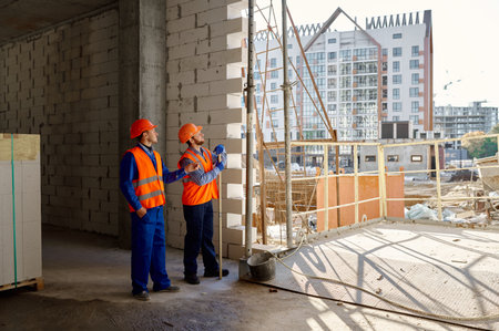 Two builders standing and talking about constructionの写真素材