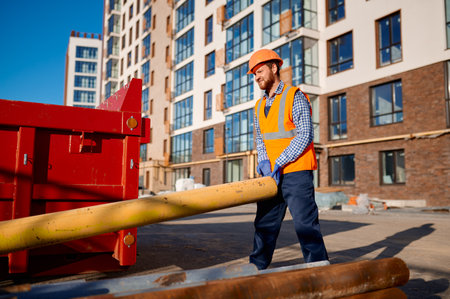 Construction worker holding pipe on site outdoors